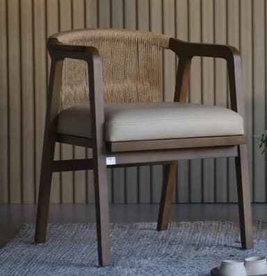 A modern armchair featuring a dark-stained wooden frame with a gently curved backrest and armrests. The backrest is composed of vertical strands of natural-colored woven rope or cord, creating an open and textural design. The seat is fitted with a thick, flat, light beige or cream-colored upholstered cushion. The chair stands on four straight, tapered wooden legs. — 3D model