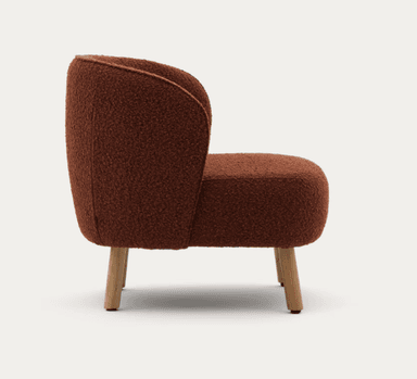 A low-profile, armless lounge chair upholstered in a textured, reddish-brown (burnt orange) boucle fabric. The chair features a compact, rounded silhouette with a gently curved backrest that flows into the deep seat. It is supported by four short, subtly splayed wooden legs. — 3D model