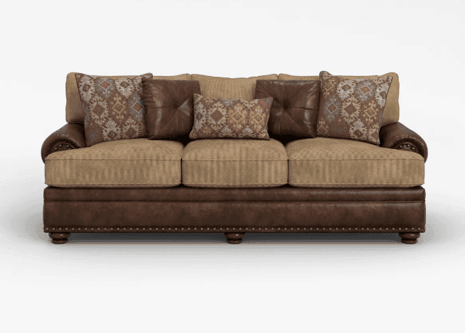 A three-seater sofa featuring a combination of dark brown faux leather and textured beige fabric upholstery. It has rolled arms with prominent nailhead trim and three separate seat cushions. The back cushions are also upholstered, and it comes with several decorative throw pillows in coordinating solid brown (tufted) and patterned fabric designs. The sofa rests on short, turned bun feet. — 3D model
