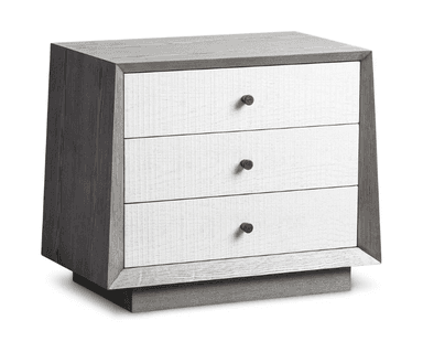 A contemporary nightstand with a distinctive design. It features a grey-toned wooden frame with a weathered texture and a contrasting white front panel. The front is composed of three drawers, each with a small, round, brown knob for a handle. The nightstand is elevated by a solid base with a beveled edge. — 3D model