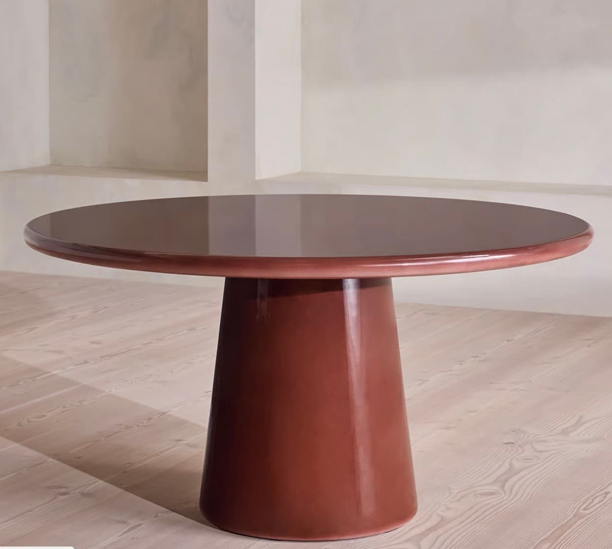 A pedestal table with a round, glossy top and a single, flared pedestal base. The base tapers from the tabletop to a wider circular foot. The overall form is smooth and monolithic. — 3D model