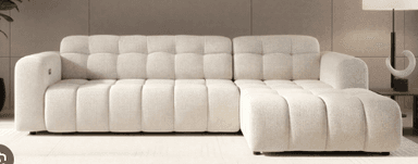 A modern, light-colored sectional sofa featuring distinct channel tufting across its seat and backrests, complete with a generously sized chaise lounge component. The design emphasizes a low profile and clean, rectilinear lines, presenting a contemporary aesthetic. — 3D model