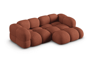 A modular sofa with a rounded, puffy design, featuring distinct individual cushions for the seat and backrest. The sofa appears to be upholstered in a textured fabric and is configured in an L-shape, with an armrest on the left side. — 3D model