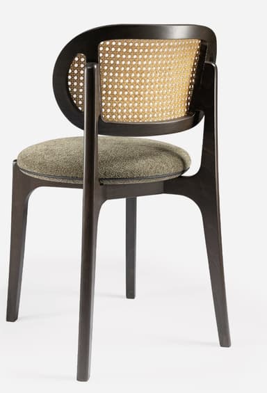 A modern side chair featuring a dark wooden frame with a distinctive curved backrest. The backrest incorporates a woven cane panel. The seat is upholstered in a textured, neutral-toned fabric. The legs are tapered and angled outwards, contributing to a sleek silhouette. — 3D model