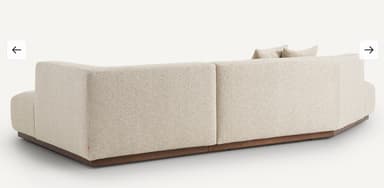 A modular sectional sofa with a low profile and clean lines. The sofa features a textured fabric upholstery and a dark wood base. It is configured with a chaise lounge on the left and a corner section on the right, accompanied by two square throw pillows. — 3D model