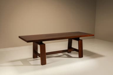 A large, rectangular solid wood table featuring a robust trestle base and a planked top. The top surface incorporates two flush-mounted rectangular covers, possibly for integrated power or cable management. The wood has a dark, rich finish. — 3D model