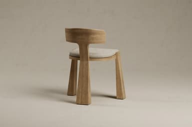 A modern wooden chair featuring a minimalist design. It has a light-colored wood frame with thick, angular, and tapered legs. The backrest is integrated into the frame, curving gently to offer support, and it is complemented by a light-colored, padded fabric seat cushion. The chair's aesthetic is clean and contemporary. — 3D model