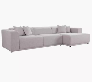 A section of a light gray, upholstered sofa is visible against a white background. The sofa features a modular design with distinct seat and backrest cushions. One armrest and part of a side cushion are also visible. The upholstery has a textured appearance with a subtle flecked pattern. — 3D model