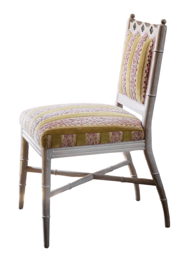 A side chair with a light-colored, possibly painted wooden frame. The frame features faux bamboo turnings on the legs and structural elements, with decorative carvings at the top of the backrest. The seat and backrest are upholstered with fabric that has a pattern of alternating wide golden yellow stripes and narrower stripes with a floral or damask-like motif in a darker pinkish-red and yellow. The upholstery appears to be velvet or a similar textured fabric. — 3D model