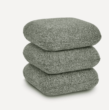 A stack of three square-shaped, soft cushions, upholstered in a speckled grey-green fabric. The cushions appear to be filled with a soft material, giving them a slightly rounded, plush appearance. They are neatly stacked on top of each other. — 3D model