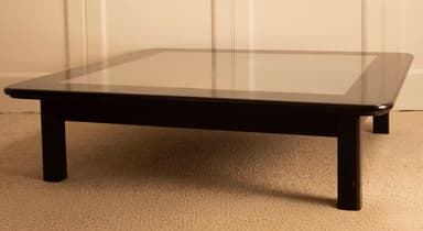 A low-profile square coffee table with a dark-finished wooden frame and a recessed, lighter-colored central panel on its top. It stands on four stout, straight legs. — 3D model