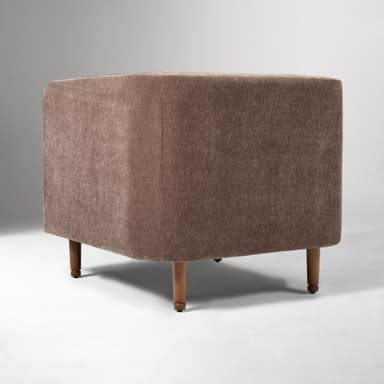 A contemporary upholstered club armchair featuring a single, removable seat cushion, integrated flared arms, and a low back, all covered in a textured, brown fabric. The chair stands on four tapered wooden legs. — 3D model