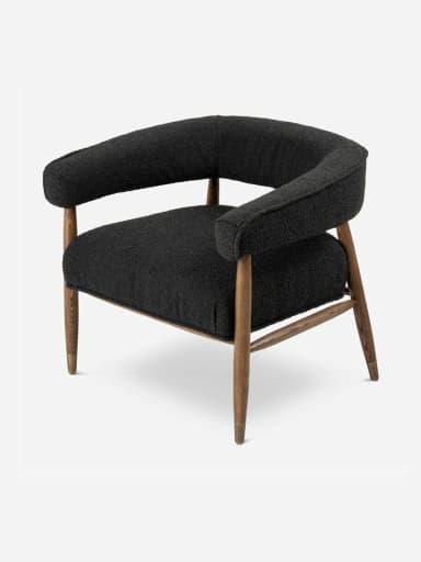 A modern upholstered accent armchair featuring a black bouclé fabric, a solid wooden frame, and tapered legs with brass caps. — 3D model
