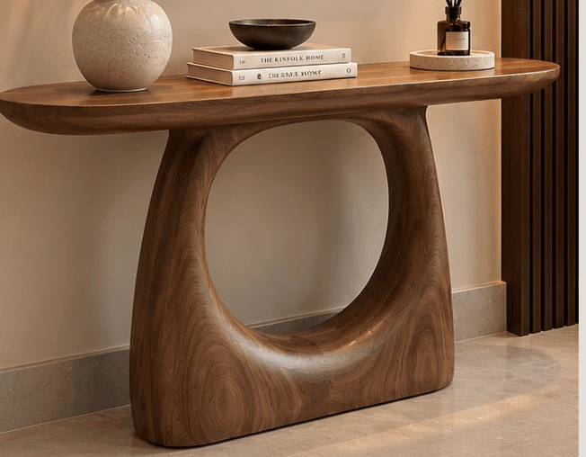 An organic modern console table crafted from dark walnut wood, featuring a smooth, oblong tabletop and a distinctive sculptural base with a curvilinear, open form. The entire piece appears to be seamlessly constructed, showcasing the natural grain of the wood. — 3D model