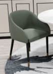 A modern upholstered armchair featuring a curved backrest and integrated armrests. The chair is upholstered in a smooth, matte olive green fabric or leatherette. It stands on four slender, tapered legs in a dark, likely black, finish, each capped with a brass or gold-toned ferrule at the foot. The design is minimalist and elegant. — 3D model