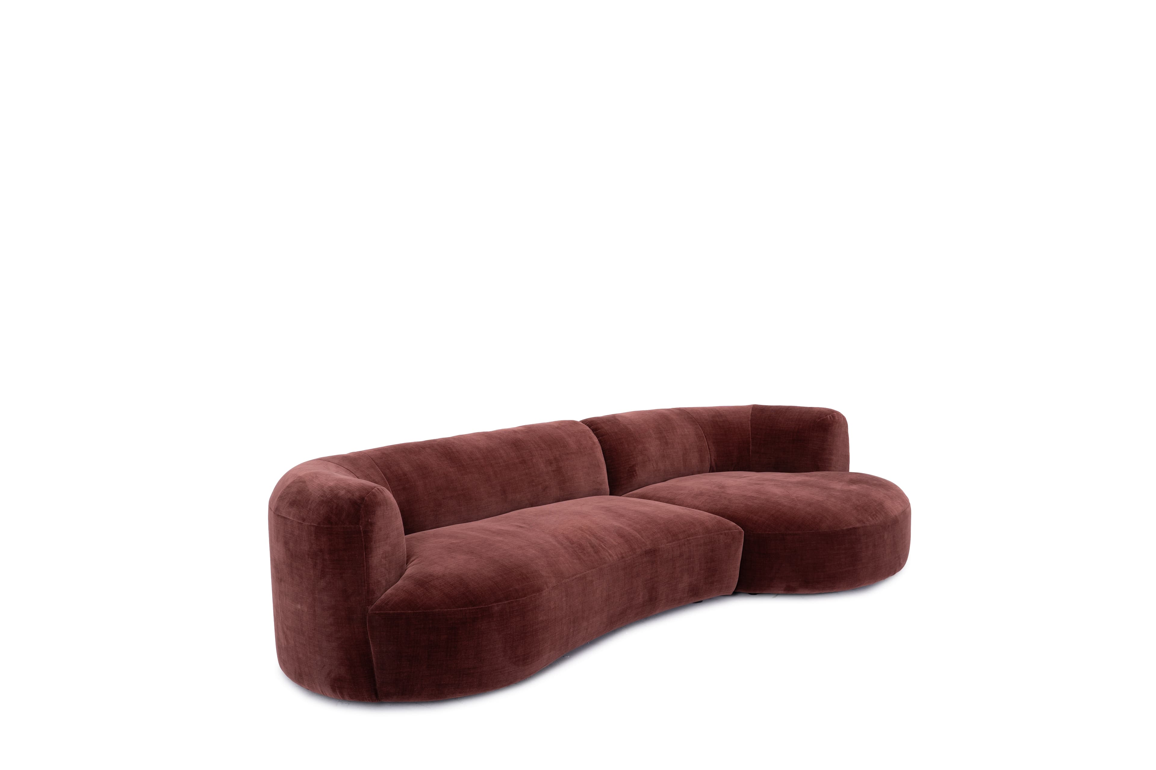 A contemporary curved sectional sofa featuring a plush reddish-brown velvet upholstery and an integrated chaise component. The sofa has a low-profile design with rounded armrests and a seamless, flowing silhouette, suggesting a modern aesthetic. — 3D model