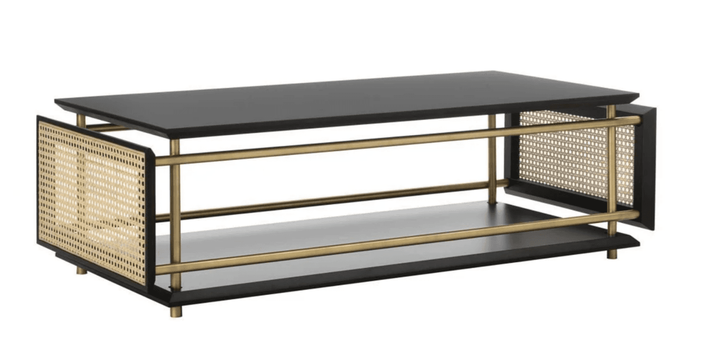 A rectangular coffee table featuring a black tabletop and a lower shelf. The frame consists of polished brass-colored metal rods, supporting the tabletop and lower shelf. The sides of the table incorporate woven cane panels within dark frames. It is supported by four small, cylindrical brass-colored feet. — 3D model