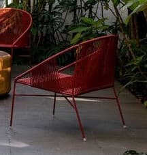 A contemporary red lounge chair featuring a sturdy metal frame intricately wrapped with woven cords to form the seat and backrest. Its design is characterized by a low profile, wide stance, and a gently curved back, providing a comfortable and relaxed seating experience. — 3D model