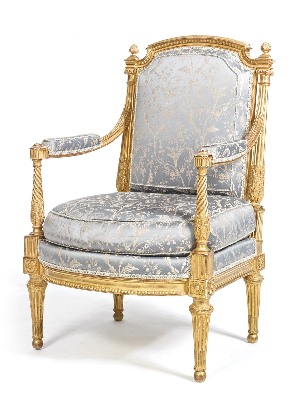 An ornate Louis XVI style armchair featuring an extensively gilded and carved wooden frame, upholstered in a light blue-gray brocade fabric with a gold floral pattern. It has a high, rounded back, padded armrests, fluted tapered legs, and decorative finials. — 3D model