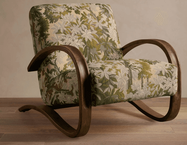 A vintage armchair featuring a high-backed design with curved wooden armrests and a patterned upholstery. The base consists of curved wooden legs that extend from the armrest structure, creating a cantilevered effect. The upholstery is a tapestry-style fabric with a floral motif in shades of green, beige, and white. — 3D model