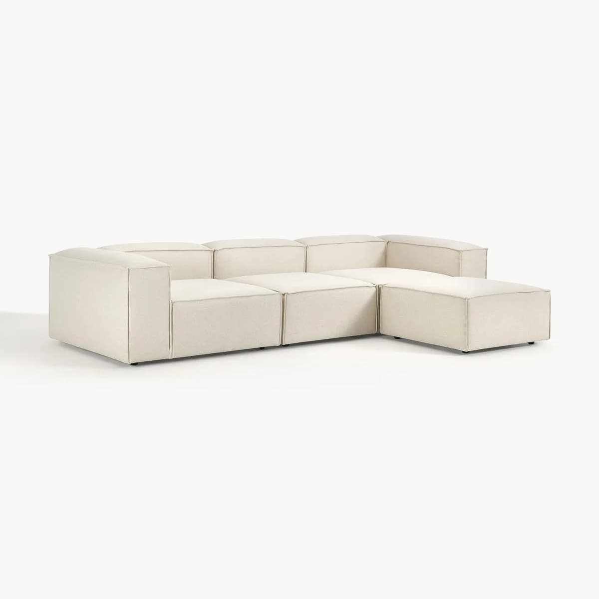 A cream-colored, modern modular sectional sofa, configured in an L-shape with a chaise lounge extension. The design features low-profile arms and backrests, with visible piping or top-stitching along all edges, indicating its modular construction with separate, upholstered blocks. — 3D model
