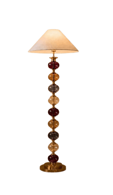 A tall, elegant floor lamp featuring a base constructed from a series of stacked, multi-colored translucent glass orbs separated by brass-toned metal rings, culminating in a simple, conical fabric shade. The orbs vary in color, including deep red, amber, and greyish hues, providing a striking visual appeal. The lamp rests on a sturdy, circular brass-toned metal base. — 3D model