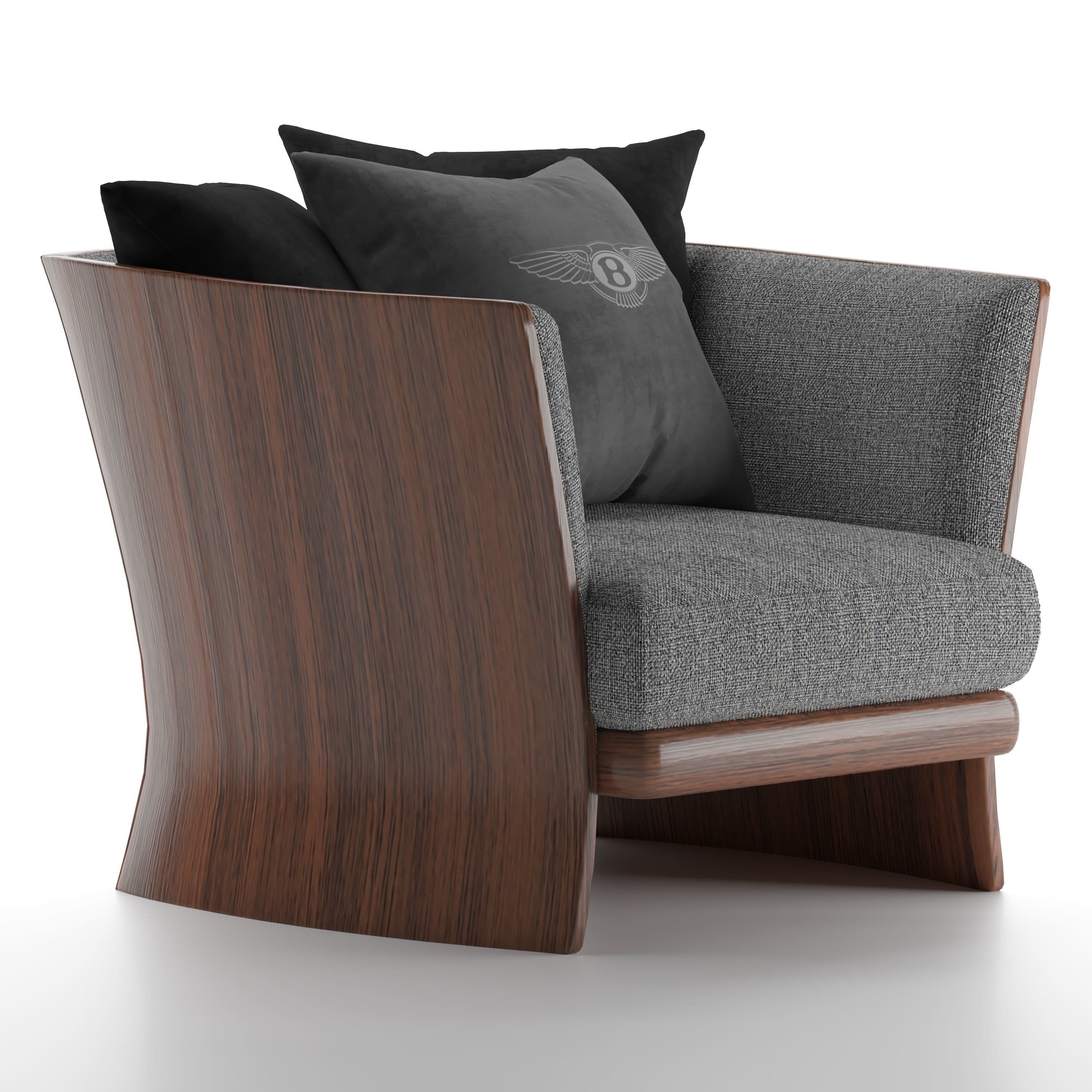 A sophisticated lounge chair featuring a distinctive dark wood frame that curves elegantly to form the back and sides, encasing a comfortable grey upholstered seat and backrest. The chair includes two black and one grey throw pillows, one of which features a winged logo, suggesting a luxury brand affiliation. — 3D model