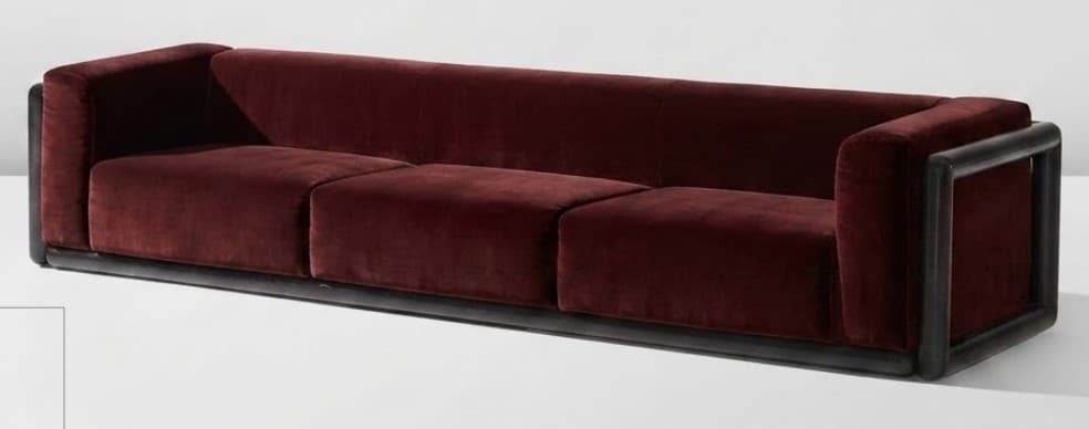 A long, three-seater sofa upholstered in deep burgundy velvet, featuring a minimalist dark wooden or metal frame that forms the base and open armrests. It has three distinct seat cushions and a continuous backrest. — 3D model