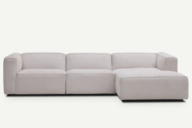 A contemporary light beige modular sectional sofa with an L-shaped configuration, featuring a chaise lounge extension, low-profile design, and block arms. — 3D model