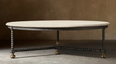 An oval coffee table featuring a light-colored, rough-hewn stone tabletop. The base consists of a dark, textured metal frame supporting four barley-twist style legs, which are interconnected by a stretcher of similar twisted design. Each leg terminates in a spherical brass foot. The overall aesthetic is rustic and traditional. — 3D model