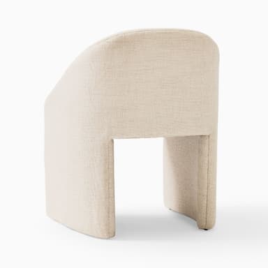 A compact, contemporary barrel-back accent chair, fully upholstered in a light beige or cream textured fabric, featuring a continuous curved backrest that integrates into armrests, and a solid plinth-style base. — 3D model