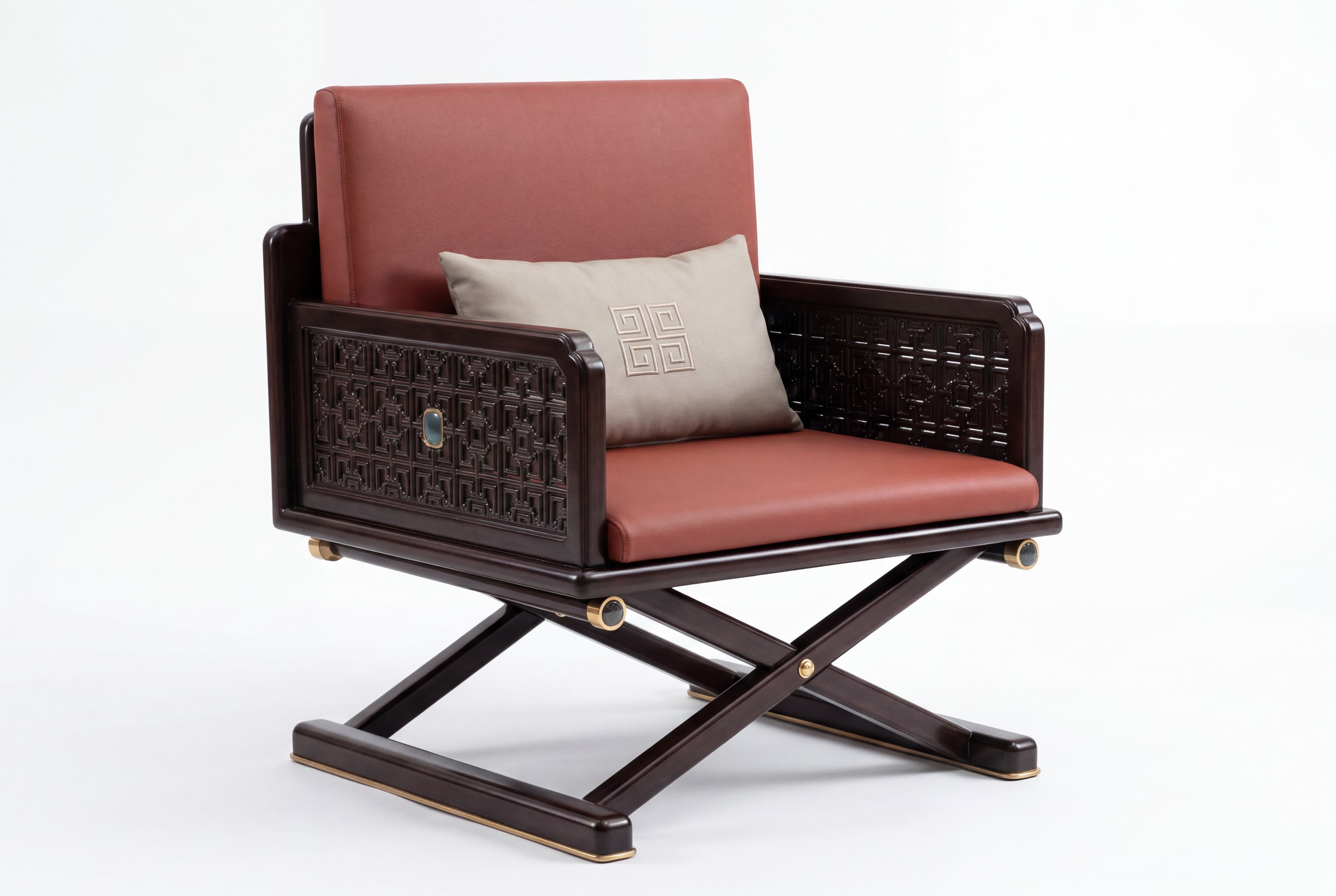 A dark wood armchair with a reddish-brown leather seat and back. The armrests feature intricate geometric carvings and a decorative inset gem on the left armrest. The chair is supported by a dark wood X-shaped base with brass accents on the legs and joints. A light-colored decorative pillow with a geometric pattern is placed on the seat. — 3D model