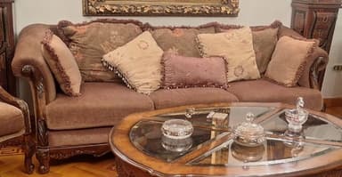 An ornate, oval-shaped coffee table with a dark-stained wooden frame and a segmented glass top. The table features intricate carvings, curved cabriole legs, and a rich, traditional aesthetic. — 3D model