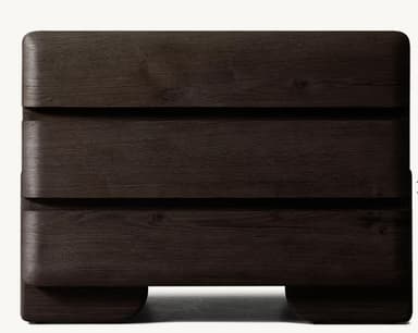 A compact, modern nightstand featuring three drawers, constructed from dark wood with visible grain. The design is characterized by softly rounded edges on the top, sides, and drawer fronts, giving it a sleek, contemporary appearance. It sits on a slightly recessed plinth base, creating a floating effect. The drawer fronts are handle-less, suggesting integrated or push-to-open mechanisms. — 3D model
