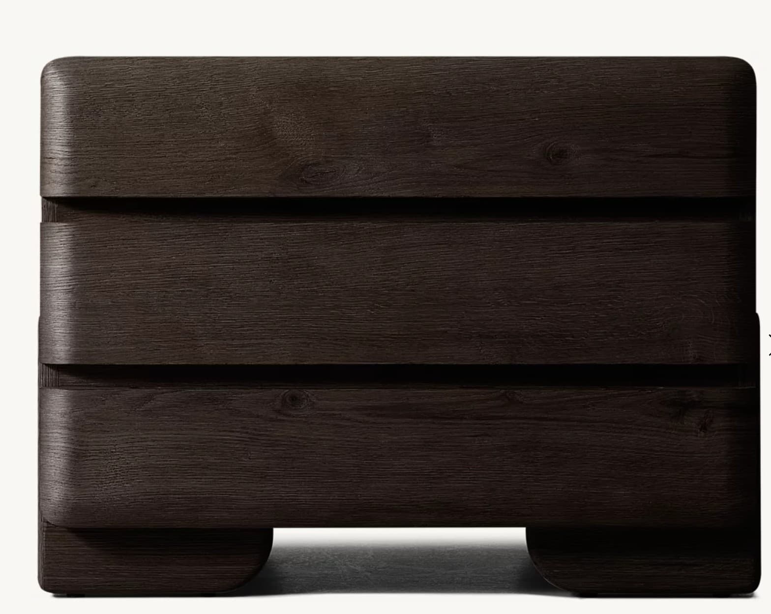 A compact, modern nightstand featuring three drawers, constructed from dark wood with visible grain. The design is characterized by softly rounded edges on the top, sides, and drawer fronts, giving it a sleek, contemporary appearance. It sits on a slightly recessed plinth base, creating a floating effect. The drawer fronts are handle-less, suggesting integrated or push-to-open mechanisms. — 3D model