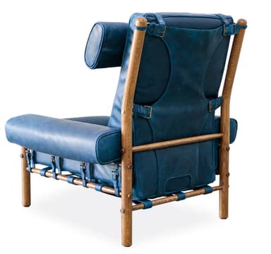 A high-backed armchair with a distinct, padded headrest secured by leather straps. The seat and back cushions are segmented, creating a tufted appearance. The frame is constructed from natural wood posts, with visible metal fasteners and leather strapping supporting the seat. — 3D model