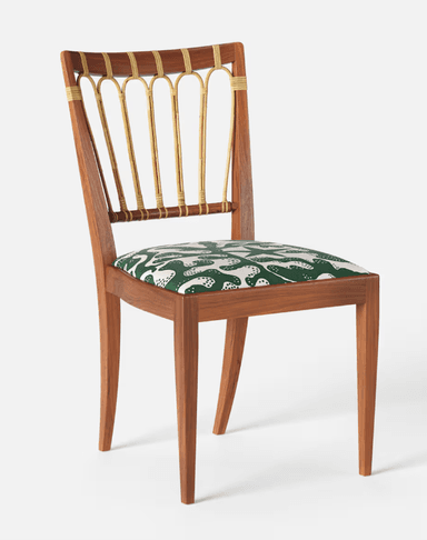 A wooden chair with a curved backrest featuring vertical, cane-wrapped spindles and a padded seat upholstered in a green fabric with a white abstract pattern. The chair has a solid wooden frame with four tapered legs. — 3D model