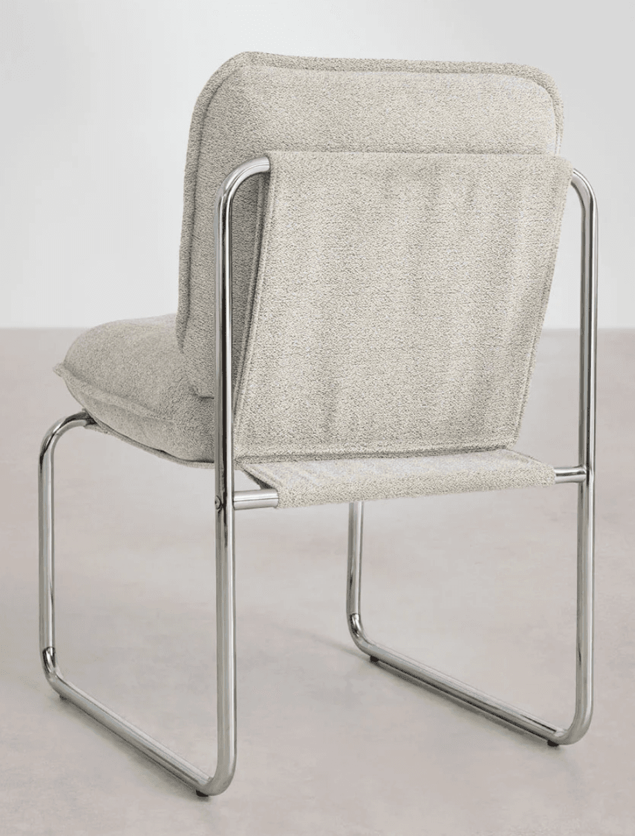 A modern armchair with a tubular metal frame and upholstered seat and back. The frame is constructed from polished chrome tubular steel, forming a cantilevered base and armrests. The seat and backrest are padded and covered in a textured, light grey fabric with a visible weave. The backrest appears to be a single piece of fabric stretched taut between the metal supports, while the seat is a separate cushion. — 3D model