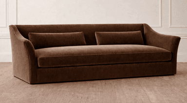 A contemporary three-seater sofa upholstered in a rich brown fabric, featuring a single, long bench cushion for seating. The backrest is gently sloped, flowing into slightly outward-curving, low-profile armrests. Two matching cylindrical bolster pillows are placed against the backrest. The sofa has a clean, minimalist base, suggesting a low-profile design without visible legs. — 3D model
