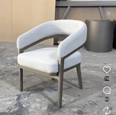 A modern upholstered club chair featuring a light gray fabric seat and a continuous, curved backrest and armrest section. This upholstered component is integrated into a distinct dark gray or bronze-colored exposed frame, which also forms the chair's four tapered legs. The design emphasizes clean lines and a contemporary aesthetic. — 3D model