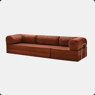 A modular sofa with a linear design, featuring stacked rectangular cushions upholstered in a corduroy-like fabric. The sofa is supported by a polished metal frame that runs horizontally along the front and sides, creating a distinct aesthetic. The cushions appear to be generously filled and have a soft, plush texture. The overall structure suggests a contemporary or mid-century modern style. — 3D model