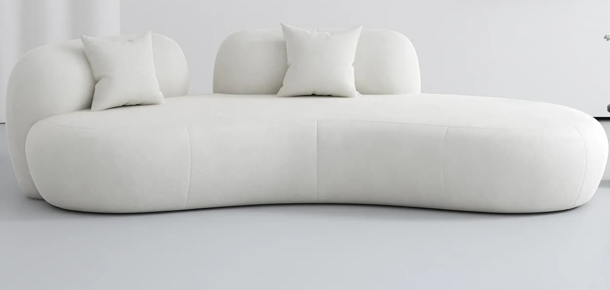 A contemporary sofa featuring a curvilinear, organic form, upholstered in a textured white fabric, and accompanied by small, matching throw pillows. The backrest is composed of distinct, rounded sections. — 3D model