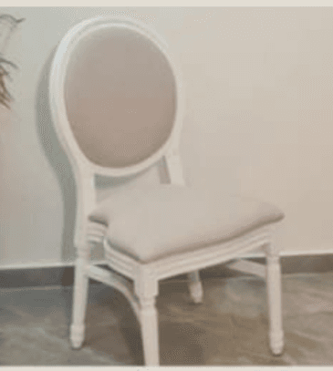 An elegant Louis XVI style dining chair featuring an oval medallion backrest and a rectangular seat, both upholstered in a light beige fabric. The wooden frame is painted in a cream or off-white finish and exhibits classical details such as fluted tapered legs and carved embellishments on the apron and leg blocks. — 3D model