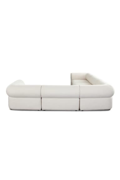 An L-shaped modular sectional sofa upholstered in an ivory or off-white textured fabric, likely bouclé. The sofa consists of multiple individual units combined to form a large seating arrangement, featuring plush, soft lines and rounded arms. — 3D model