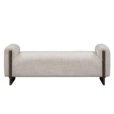 A modern upholstered bench with a textured, light-colored fabric and dark wood accents. The bench features a low profile, rounded armrests on both ends that extend slightly upwards, and a rectangular seat. The base consists of two dark wood legs, one at each end, with a unique angular design that provides support and visual interest. The overall aesthetic is minimalist and sophisticated. — 3D model