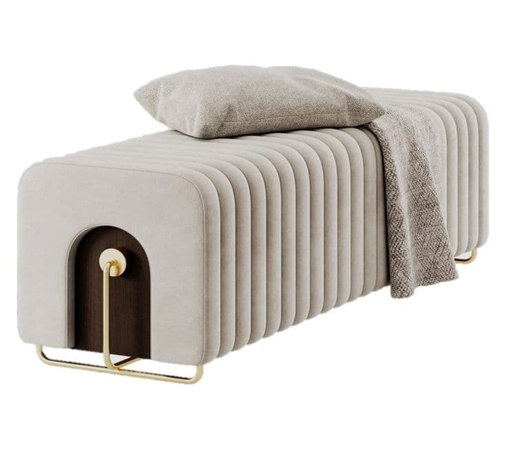 A modern rectangular bench featuring continuous ribbed upholstery in a light beige or cream color. The bench is supported by a minimalist, U-shaped brass frame that integrates into the structure, visible at both ends. One end incorporates a distinctive arched cut-out revealing a dark wood interior with a central brass disc and rod detail. — 3D model