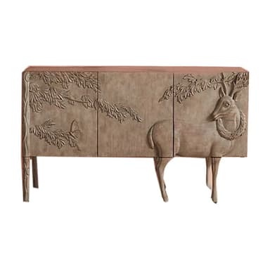 This is a carved wooden sideboard featuring intricate relief carvings of a deer with a wreath around its neck and foliage with butterflies. The cabinet has a rectangular form with four doors, supported by four tapered legs that extend from the cabinet body, with the front two legs designed to resemble the legs of the deer. The finish is a light, natural wood tone, enhancing the detailed carvings. — 3D model