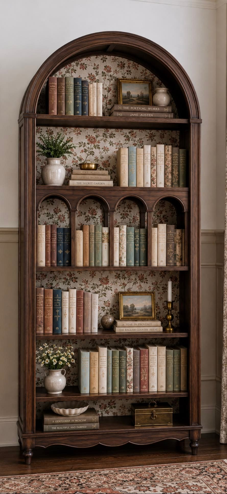 A tall, dark brown wooden bookcase featuring an arched top and a decorative floral wallpaper lining the back panel. It has multiple open shelves of varying heights, some with arched dividers, filled with books and decorative objects. The base features a scalloped apron and stands on turned bun feet. — 3D model