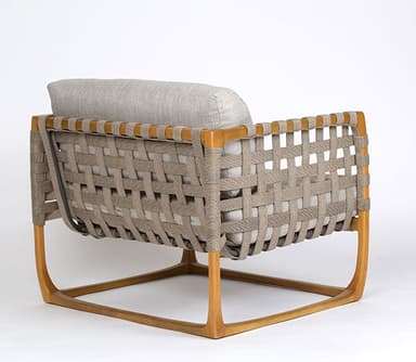 A modern lounge chair featuring a natural wood frame, woven strap detailing on the arms and back, and thick, light grey upholstered cushions. — 3D model