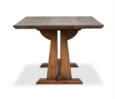 A long, rectangular wooden table with a sturdy, thick top and two trestle-style bases connected by a central stretcher. The wood has a visible grain and a dark, rich brown finish, suggesting a rustic or farmhouse aesthetic. The bases feature broad, vertical supports and wide, horizontal feet, providing a stable foundation. — 3D model